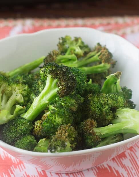 Air fried broccoli in a white bowl.