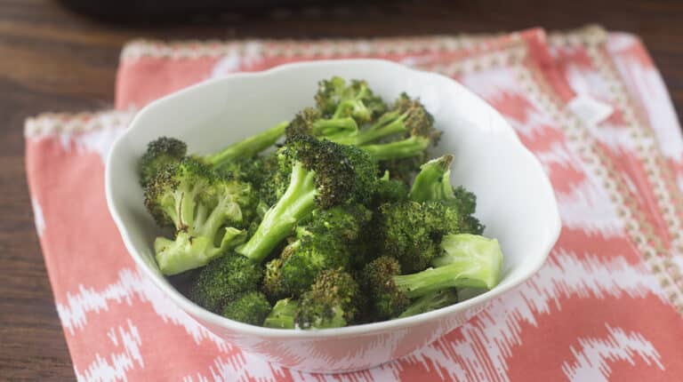 Air fried broccoli in a white bowl.