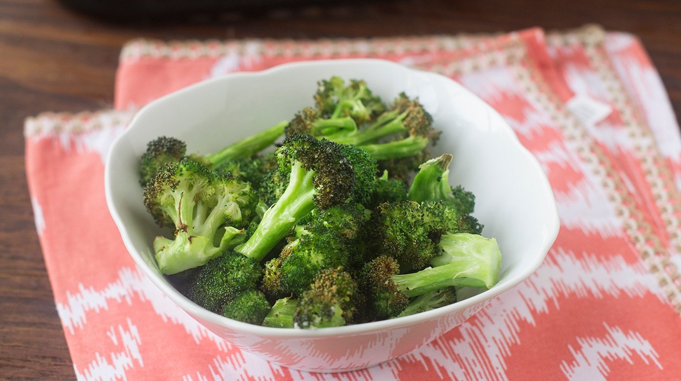 Air fried broccoli in a white bowl.