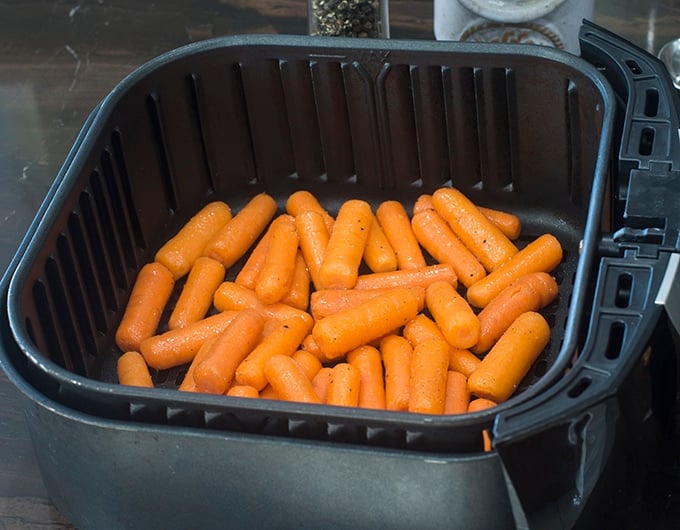 Baby carrots in the air fryer basket.