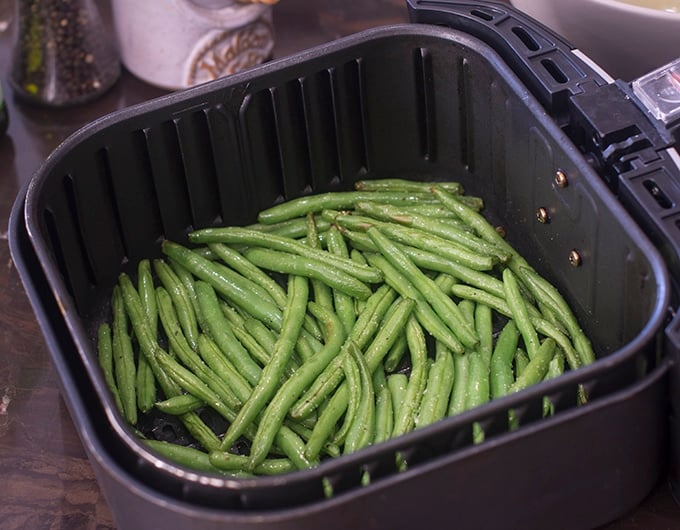 Partially cooked green beans in air fryer.