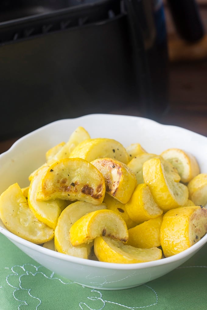 Cooked yellow squash in a white bowl.