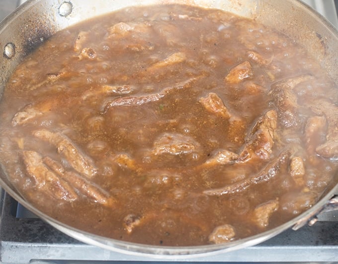 Simmering beef strips in gravy.