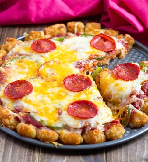 pepperoni pizza with a tater tot crust on a pizza pan.
