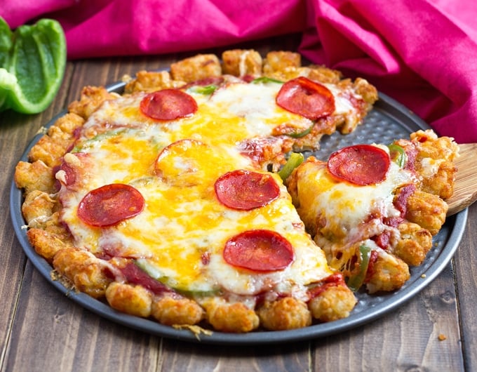 pepperoni pizza with a tater tot crust on a pizza pan.