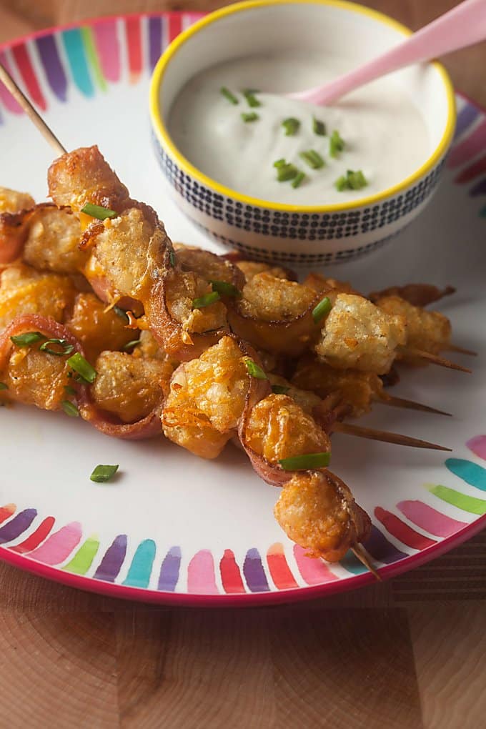 Tater Tot Skewers make a fun party appetizer or snack. Tater tots and bacon threaded on a skewer. What's not to love about that?