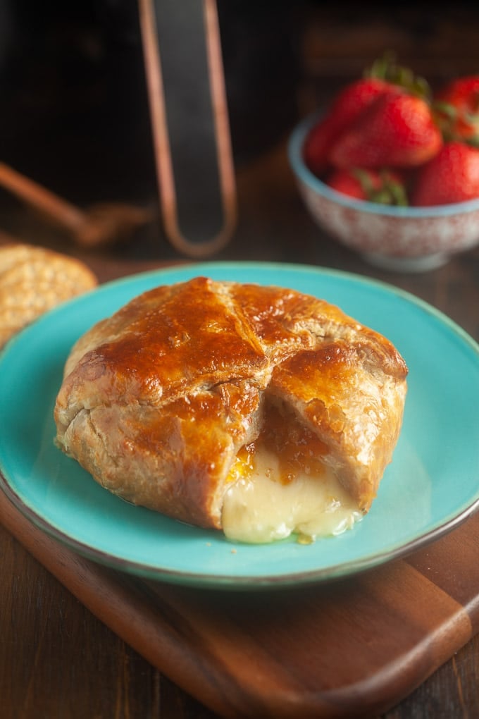 Melty brie wrapped in pastry on a blue plate.