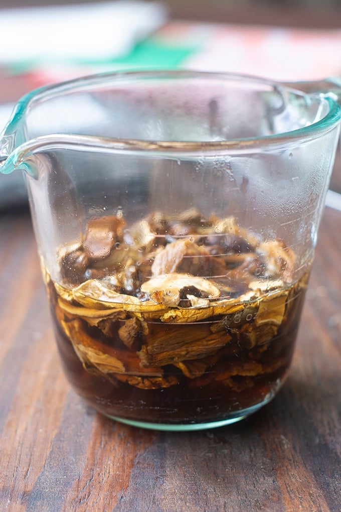 measuring cup with dried mushrooms soaking in water in it