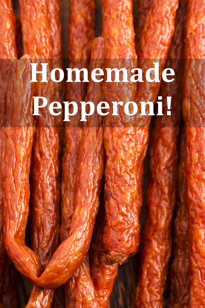 Pepperoni sticks close-up and hanging downwards with the words "Homemade Pepperoni" on the image.