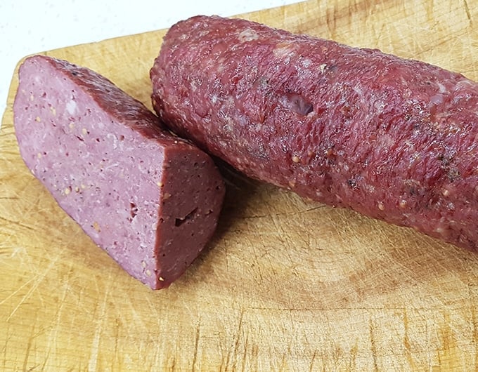 Finished salami cut open on cutting board.