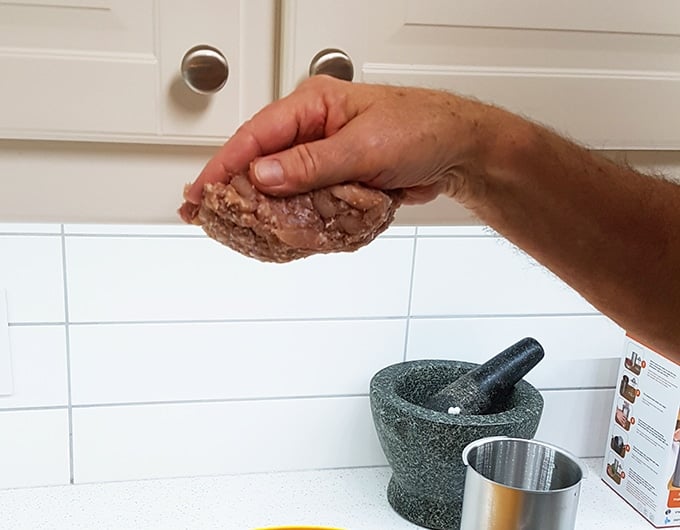 Pepperoni mixture of ground meat in a hand.