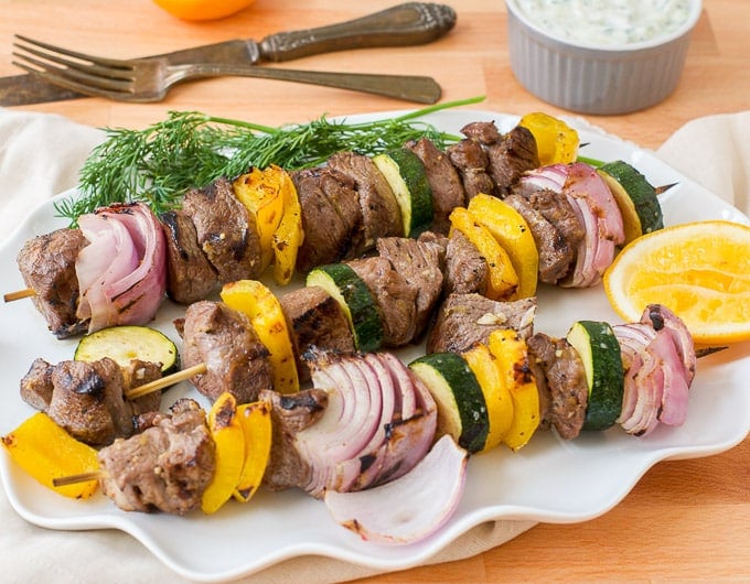 skewers with lamb, red onion, and yellow bell pepper on them