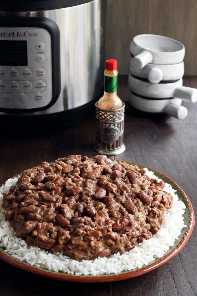 Plate of red beans over white rice in front of an instant pot.