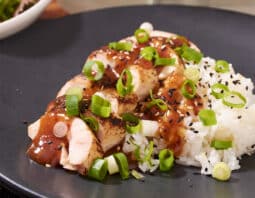 Chinese Garlic Chicken over white rice with green onion on top.