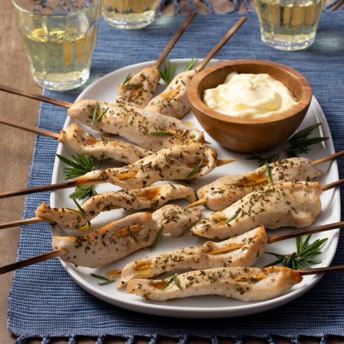 Chicken on skewers with rosemary, dish of aioli.