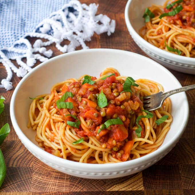 Spaghetti with lentil Bolognese in a white bowl.