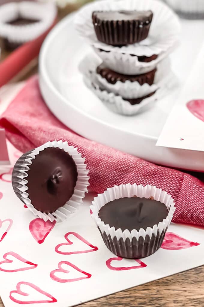 Chocolates in white mini cupcake liners, against a background of hearts and red cloth.