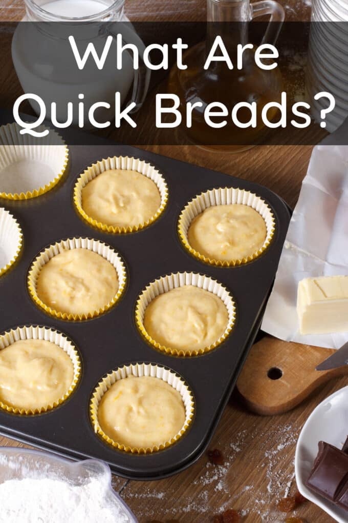 Muffin tin with batter in liners with butter and other ingredients around, text reads What Are Quick Breads?