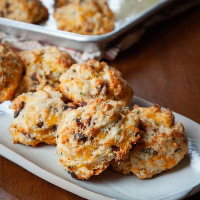 Cheesy biscuits with bacon and chives on a platter.