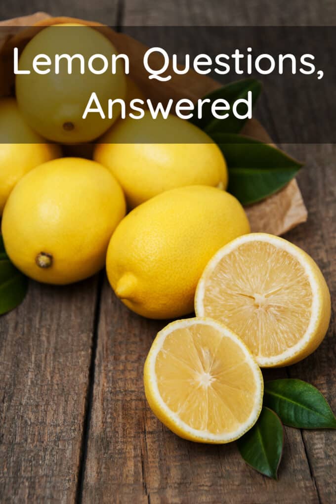 Fresh lemons, one cut in half on a wooden surface. Text reads Lemon Questions, Answered.