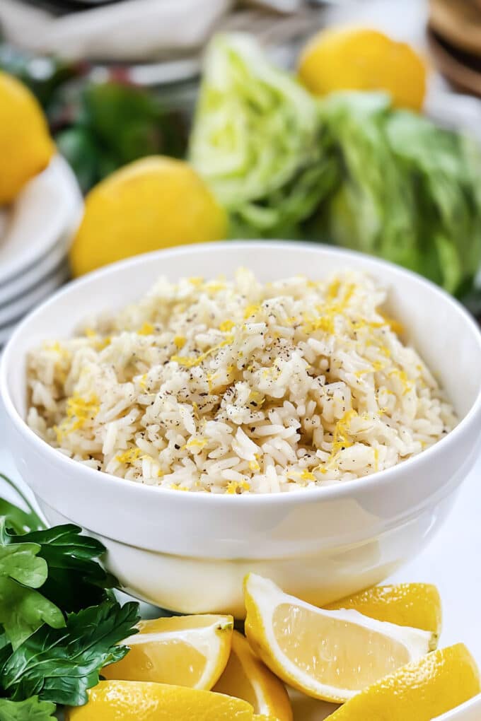 White bowl of rice topped with lemon zest and black pepper.