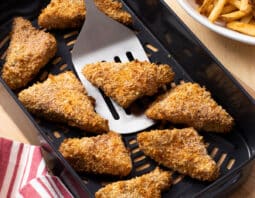 Crispy breaded fish fillet wedges in the air fryer basket