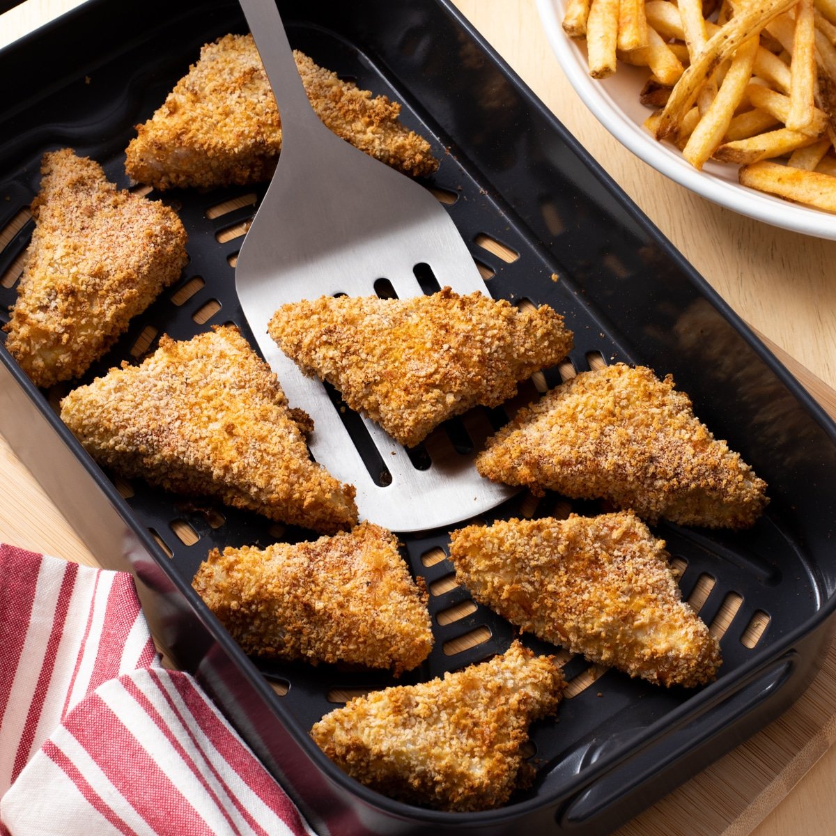 Crispy breaded fish fillet wedges in the air fryer basket