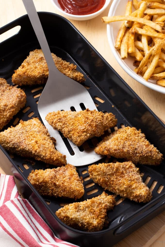 Crispy breaded fish fillet wedges in the air fryer basket