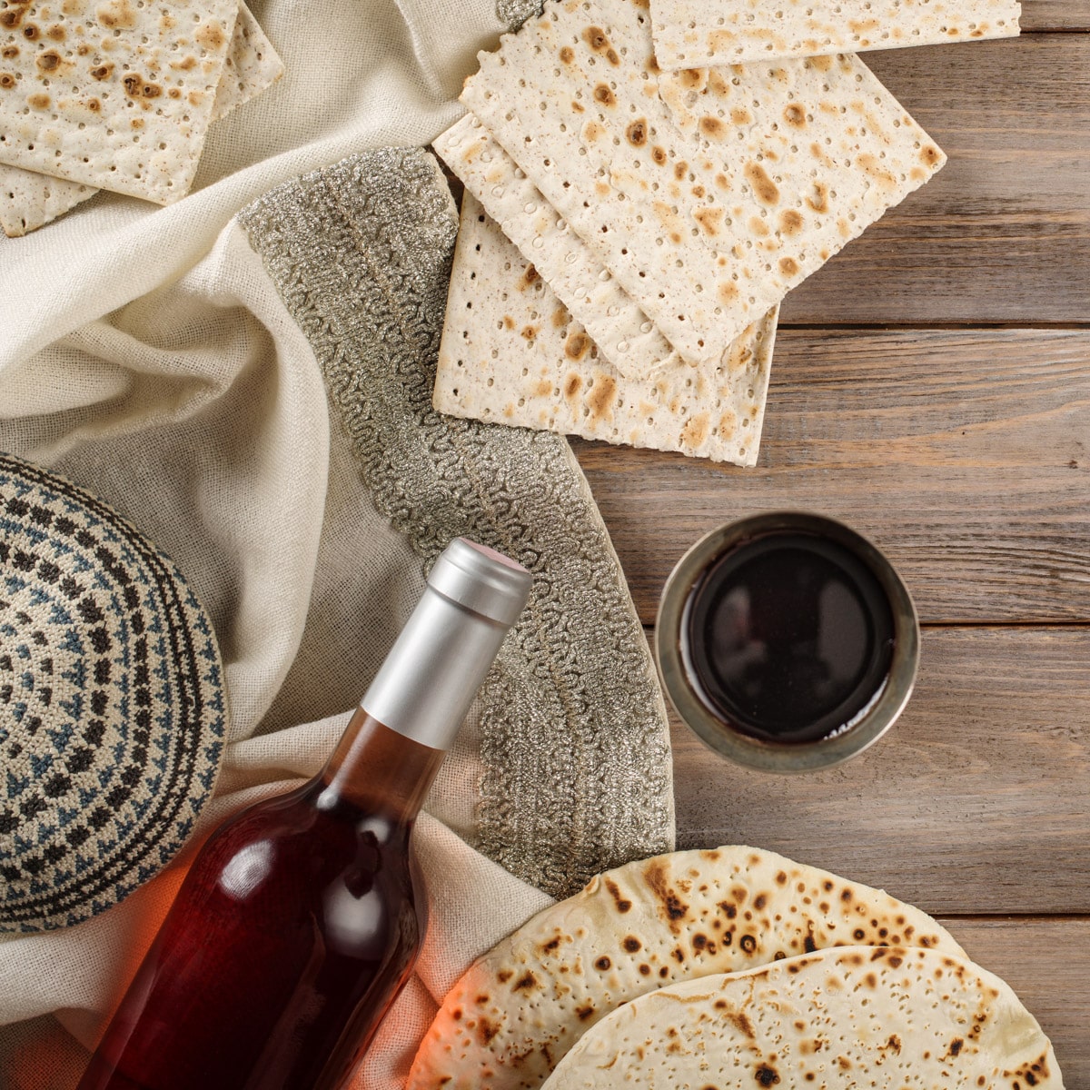 Wine and matza on a wooden table.