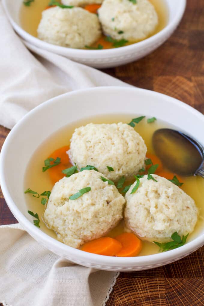 Fluffy matzo balls in chicken broth with carrots.
