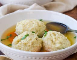 Fluffy matzo balls in chicken broth with carrots.