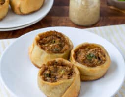 Three potato knish on a white plate.