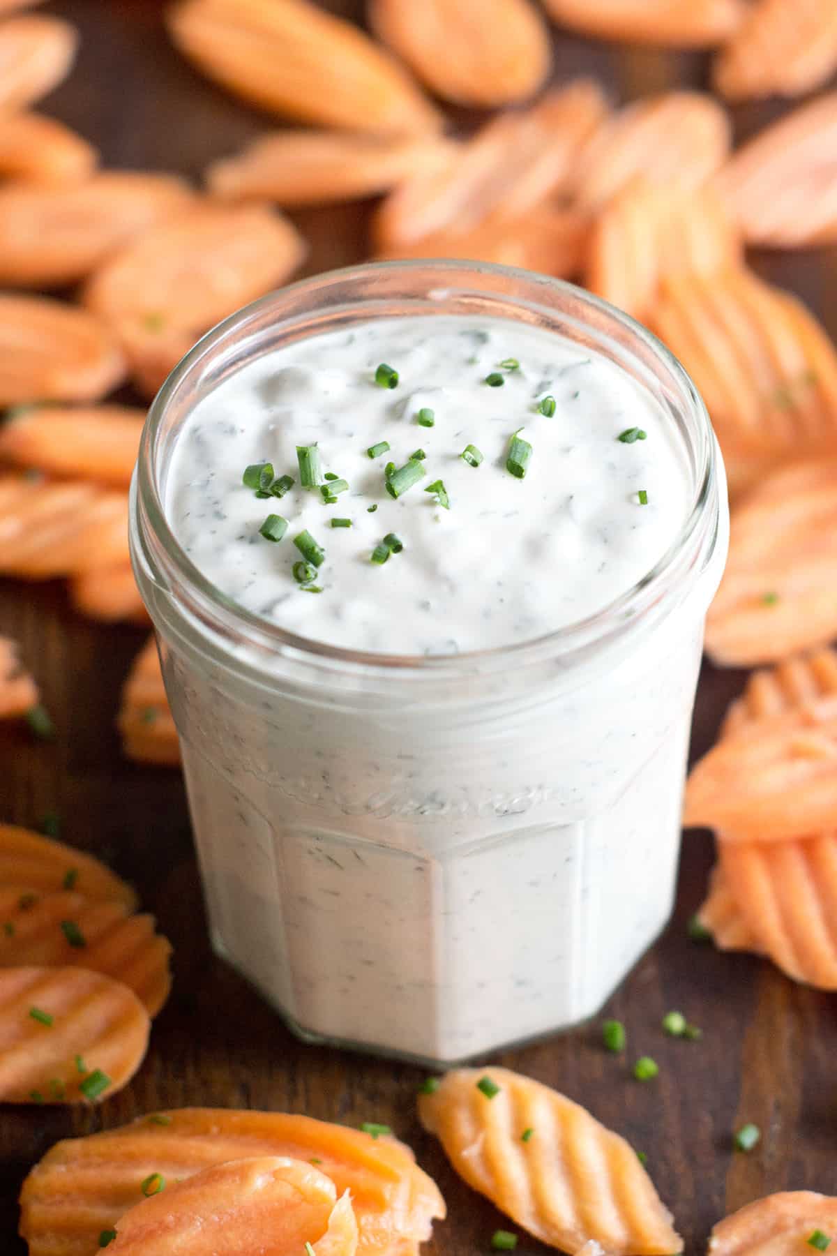 Homemade Ranch Dressing with Greek Yogurt Glass jar of homemade ranch with carrot chips around.