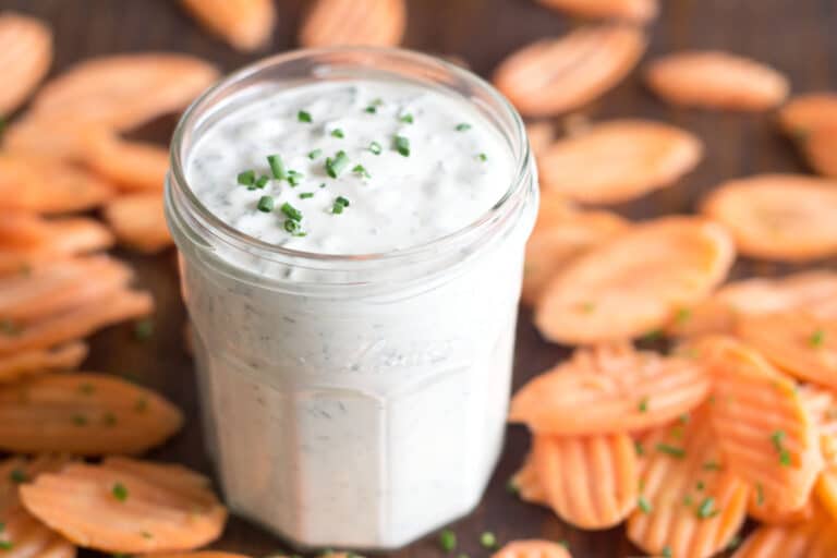 Glass jar of homemade ranch with carrot chips around.