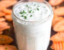 Glass jar of homemade ranch with carrot chips around.
