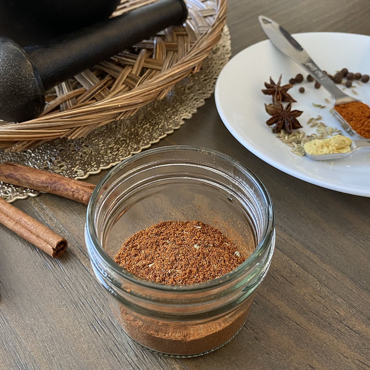 Pepperoni seasoning blend in glass jar with spices in background.