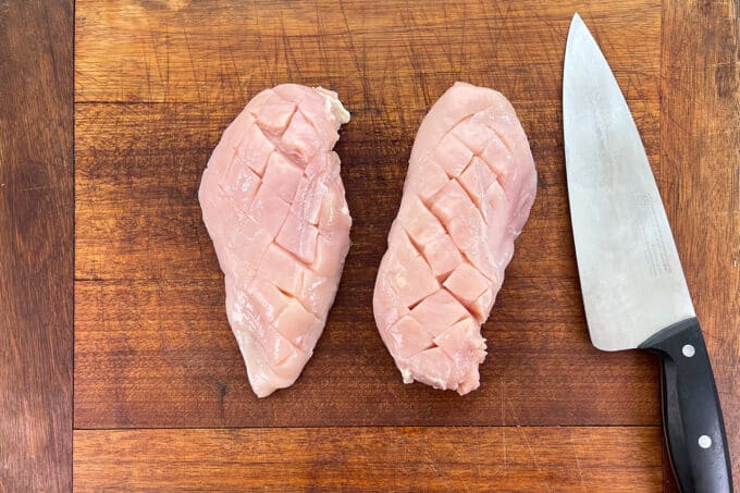 Raw chicken breasts with cross-hatched scoring