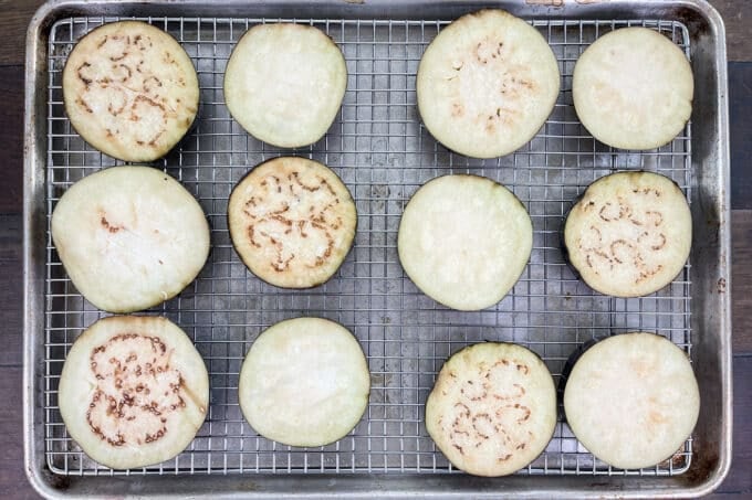 Slices of salted and unsalted eggplant resting on a rack.