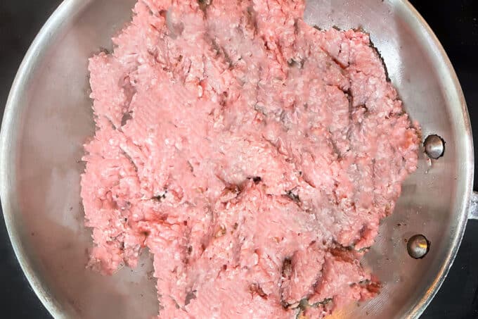 Raw ground turkey in pan with oil.
