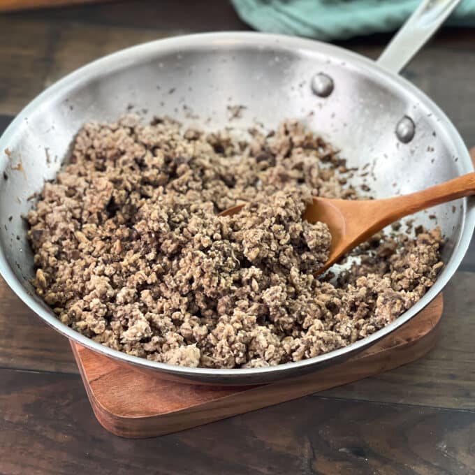 Cooked ground turkey in a pan with a wooden spoon.