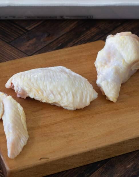 Raw chicken wing cut into three pieces.