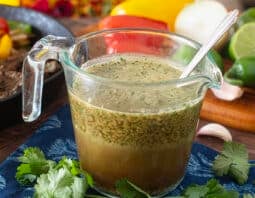 Glass measuring cup of blended marinade with spoon.