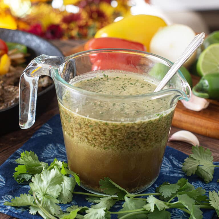 Glass measuring cup of blended marinade with spoon.
