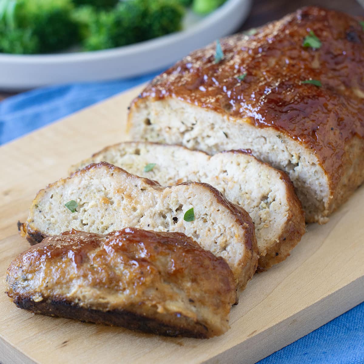 Sliced chicken meatloaf on a cutting board.