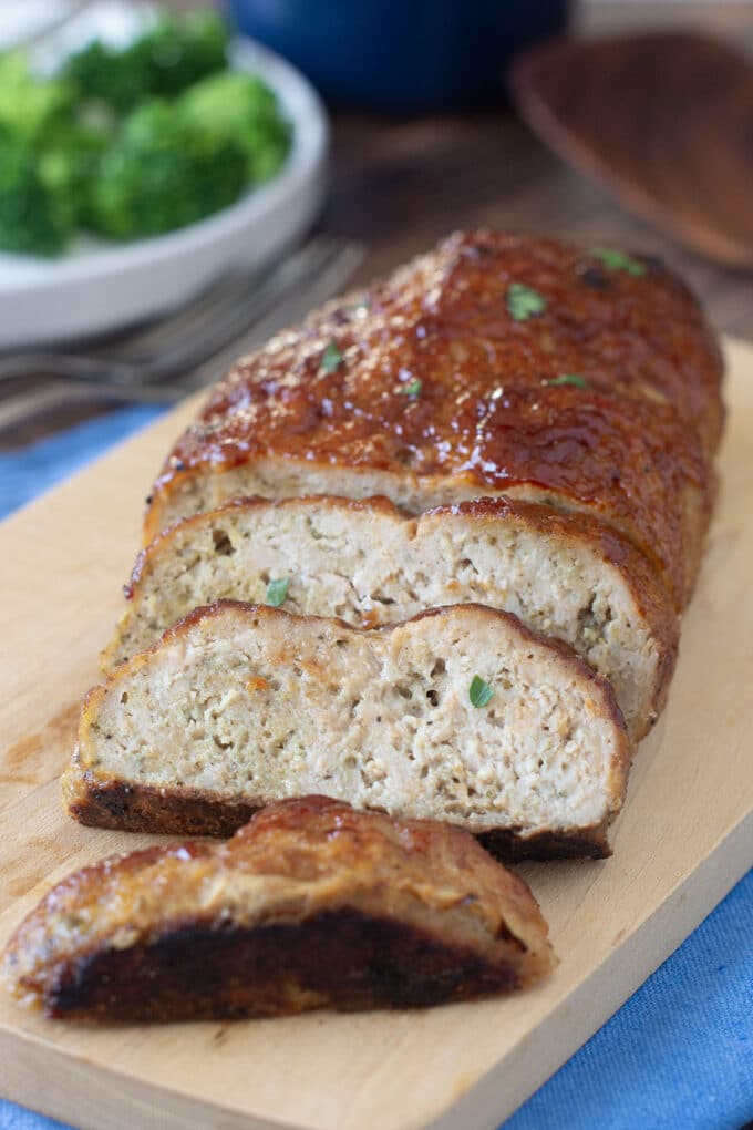 Sliced chicken meatloaf on a cutting board.