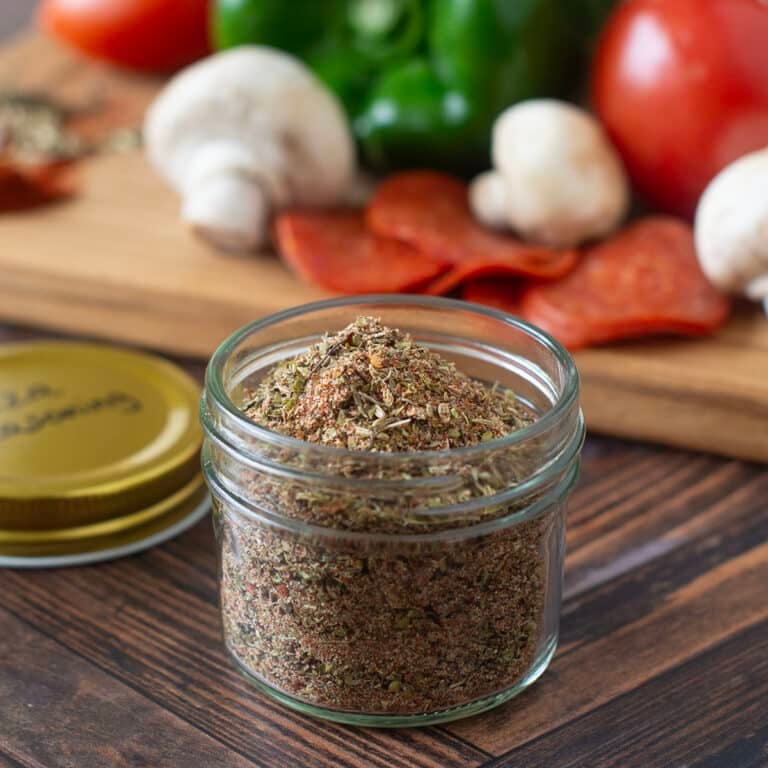 Glass jar of pizza seasoning mixture.