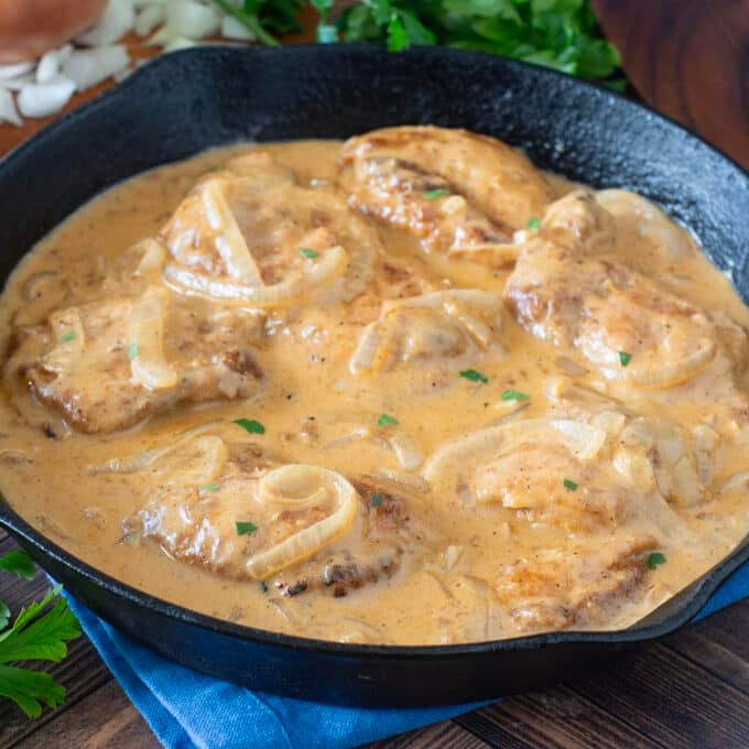 Pan of chicken thighs in a creamy onion gravy.