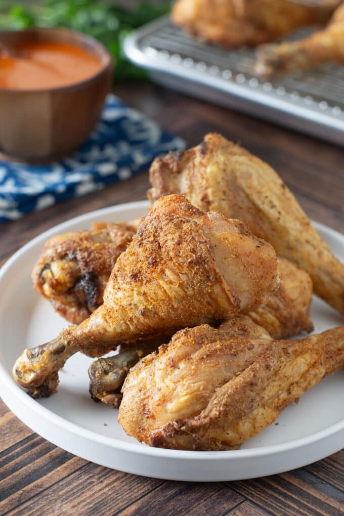 Light gray plate with pile of crispy baked chicken drumsticks.
