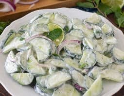 Cucumber Mint Salad with creamy dressing on a white plate.