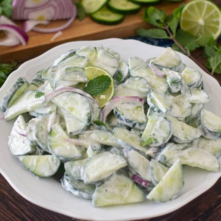 Cucumber Mint Salad with creamy dressing on a white plate.
